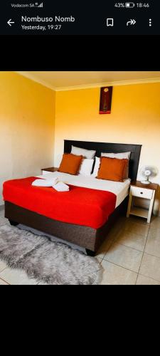 una camera da letto con un letto grande con una coperta rossa di Mbotyi Mnceba cottage a Lusikisiki