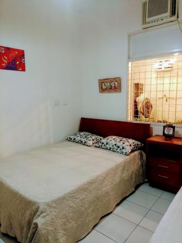 a small bedroom with a bed and a window at Pousada Morada Bonfim in Olinda