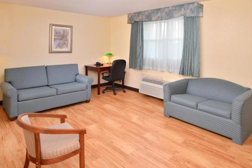 a living room with two blue couches and a desk at Tower Inn and Suites of Guilford / Madison in Guilford