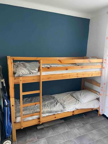 Ce lit se trouve dans un dortoir doté de 2 lits superposés et d'un mur bleu. dans l'établissement Appartement T2 proche mer, à Canet
