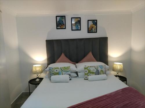 Un dormitorio con una gran cama blanca con dos lámparas. en Cethone Luxury Guest House, en Ciudad del Cabo