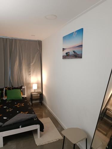 a bedroom with a bed and a picture on the wall at Plaza Caparica Hostel in Costa da Caparica