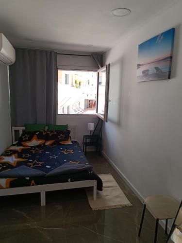 a bedroom with a bed and a window at Plaza Caparica Hostel in Costa da Caparica