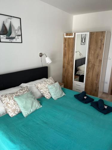 a bedroom with a bed with blue sheets and pillows at Fonyódi Fészek in Fonyód