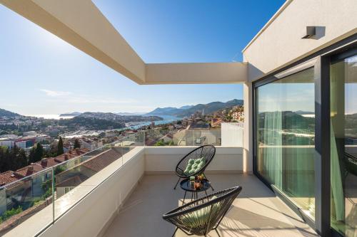 a balcony with two chairs and a view at Villa Sunset Dubrovnik in Dubrovnik