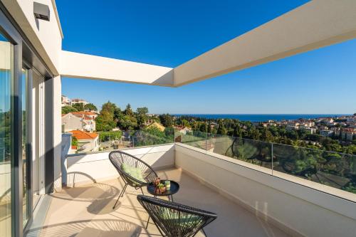 a balcony with two chairs and a view at Villa Sunset Dubrovnik in Dubrovnik