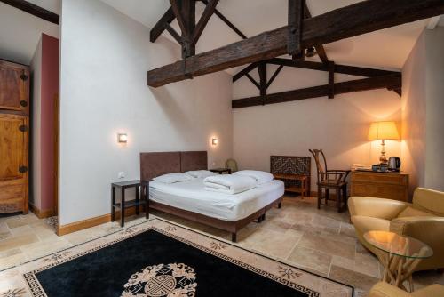 a bedroom with a bed and a couch and a table at Chateau de la Vieille Chapelle in Lugon et l’Ile du Carney