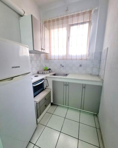 a small white kitchen with a sink and a window at Sun Ray Sivota 2 in Sivota