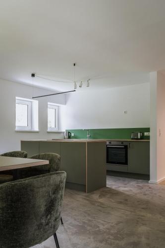 a kitchen with green and white walls and a table at Lebe' scharnitz in Scharnitz