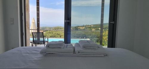 a bed with four towels on it with a view of a pool at Blue Lilac Villas in Parga