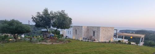 a building on top of a grassy hill at Blue Lilac Villas in Parga
