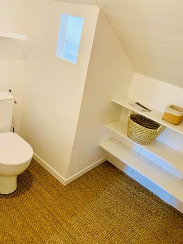 a bathroom with a white toilet in a room at Gîte Aubiacais 10 personnes in Aubiac