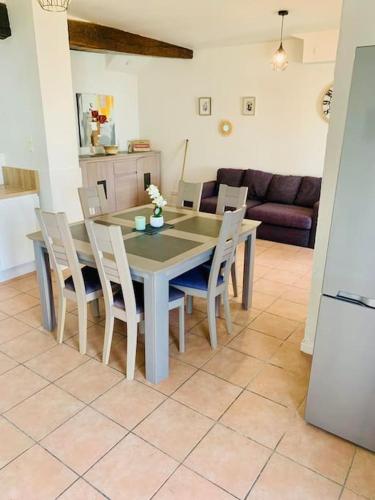 a dining table and chairs in a living room at Gîte Aubiacais 10 personnes in Aubiac
