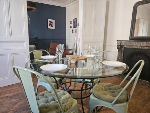 une salle à manger avec une table et des chaises en verre dans l'établissement Le Galliéni Hyper Centre, au Havre