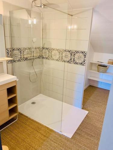 a shower with a glass door in a bathroom at Gîte Aubiacais 10 personnes in Aubiac