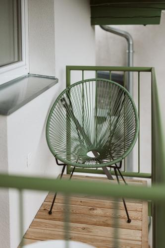 a green chair sitting on top of a wooden floor at Lebe' scharnitz in Scharnitz