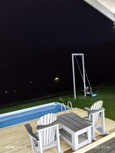 a picnic table and two chairs next to a pool at Ехо Тростяну in Slavske