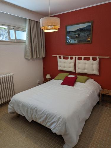 - une chambre avec un grand lit blanc aux murs rouges dans l'établissement Le cocon des passons 3 pièces 70m2, à Aubagne