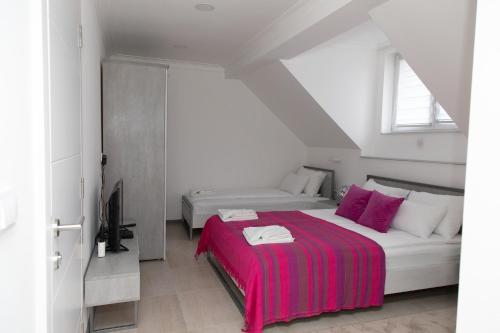 a bedroom with two beds with a red blanket at VILA Milovanović in Mataruška Banja