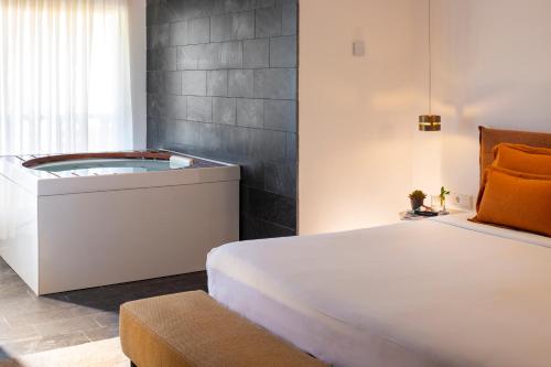 a bedroom with a bed and a bath tub at Hotel Boutique Ses Pitreras in San Antonio Bay