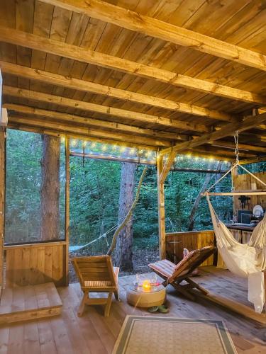 a room with a hammock in a forest at Каравана Безвремие in Chernomorets