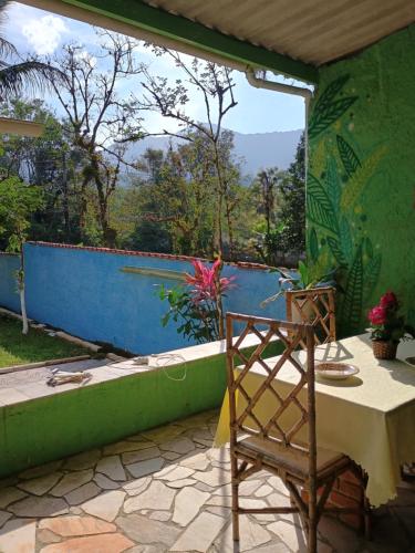 a patio with a table and a view of a pool at Renovo Beija-flor Hostel e Espaço Terapêutico in Bertioga