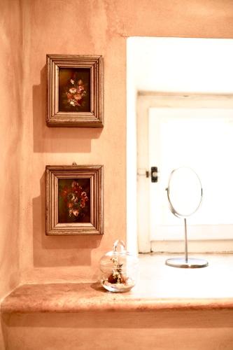 a room with a window with a mirror and a bowl of flowers at Il Convento in San Lorenzo Nuovo