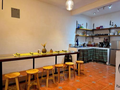 a kitchen with a table and stools in a room at Casa Don Agapito in San Pedro La Laguna