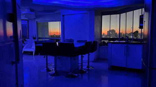 a blue room with a table and some chairs at Só Mulheres Cobertura Duplex Alto Padrão Shows Ginásio Parque Ibirapuera Jardins Av Paulista Paraíso Vl Mariana in Sao Paulo