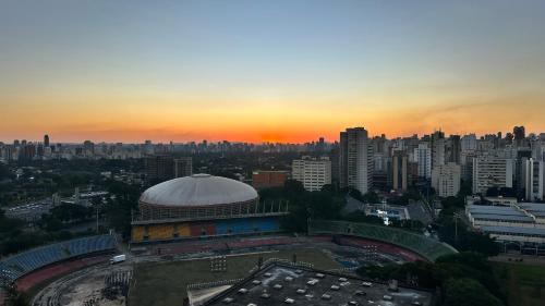a building with a dome in a city at sunset at Só Mulheres Cobertura Duplex Alto Padrão Shows Ginásio Parque Ibirapuera Jardins Av Paulista Paraíso Vl Mariana in Sao Paulo