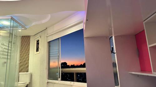 a bathroom with a window with a view of the city at Só Mulheres Cobertura Duplex Alto Padrão Shows Ginásio Parque Ibirapuera Jardins Av Paulista Paraíso Vl Mariana in Sao Paulo