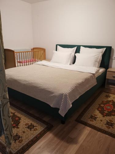 a bed with white pillows on it in a room at Casa "La padure" in Bran