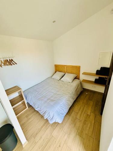 - une petite chambre avec un lit et du parquet dans l'établissement Studio de la Lauze, à Bourg-Saint-Andéol