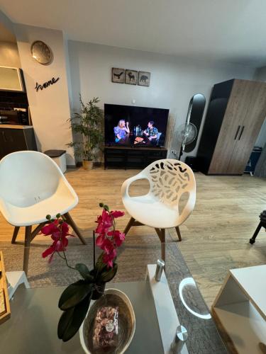Una sala de estar con dos sillas y un televisor. en Luceros best studio, en Alicante
