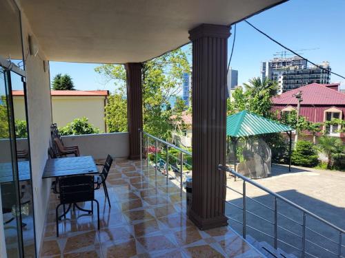 a patio with a table and chairs on a balcony at Batumi Aparthotel 22D in Batumi