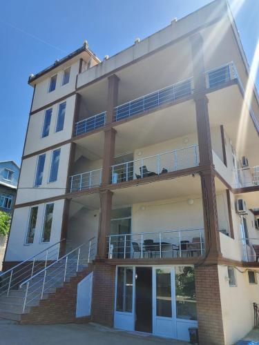 an apartment building with stairs and a balcony at Batumi Aparthotel 22D in Batumi