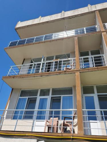 a building with chairs and tables on a balcony at Batumi Aparthotel 22D in Batumi