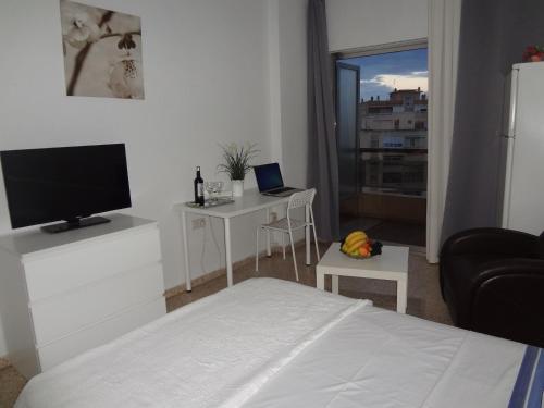 a bedroom with a bed and a tv and a window at Hotel Carlos I in Torremolinos