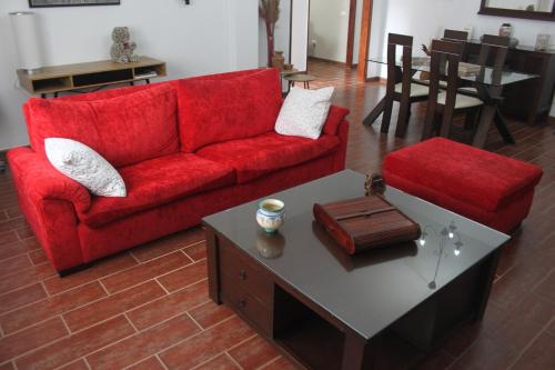 a living room with a red couch and a coffee table at Casa V del Pino in Teror