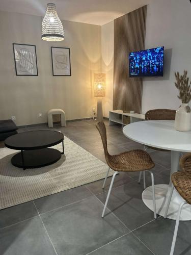 une pièce avec une table, des chaises et une télévision dans l'établissement Maison moderne au cœur de Caudry, à Caudry