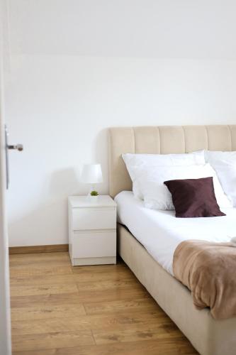 a bedroom with a bed and a white nightstand at Airport Stay Apartments in Surčin
