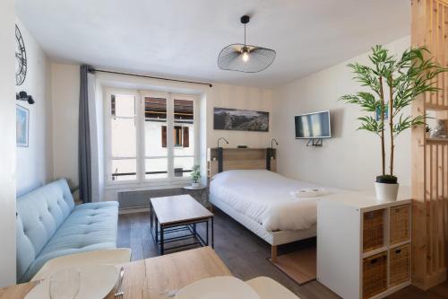 une petite chambre avec un lit et un canapé dans l'établissement Cabana & Le Cocon Annecy Centre - Proche Gare et Lac, à Annecy