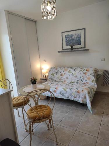 une chambre avec un lit et une table avec des chaises dans l'établissement Gîte Le Jasmin, à Saint-Andiol