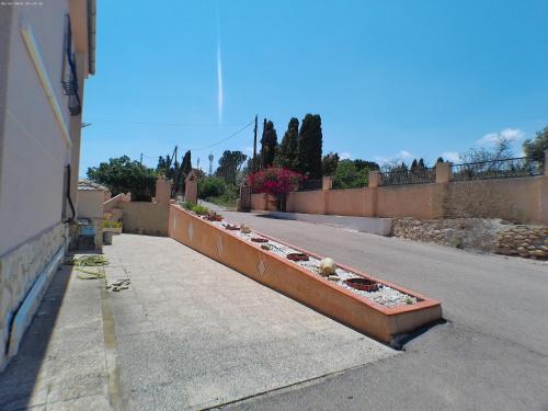 an empty street with a row of plants on a sidewalk at Chalet con piscina Umut Homes in Alicante