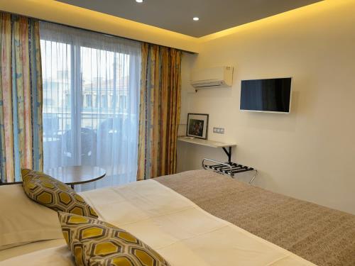 a hotel room with a bed and a television at Hotel Panorama in Grasse