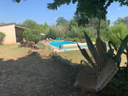 une cour arrière avec une piscine et une maison dans l'établissement Maison avec piscine, au calme, à Taradeau