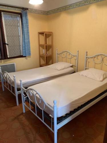 deux lits jumeaux dans une chambre avec fenêtre dans l'établissement Maison avec piscine, au calme, à Taradeau