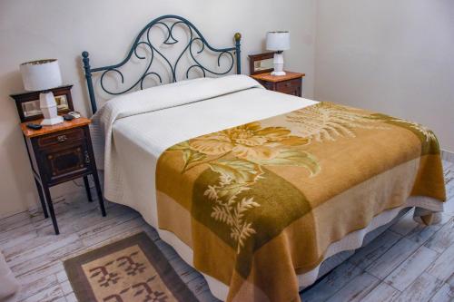 a bed in a room with two night stands and two lamps at CASA Del RODEO in General Ramírez