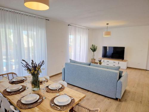 Una sala de estar con un sofá azul y una mesa. en Rustic House Konfidenca, en Biograd na Moru