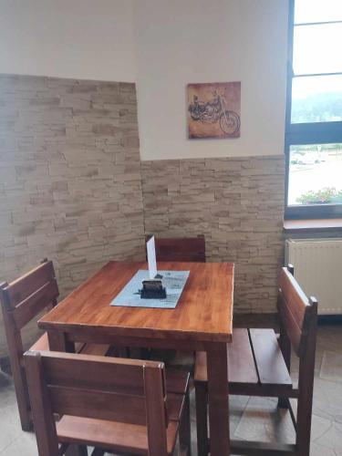 a wooden table with chairs and a box on top at Penzion a restaurace Na Salaši in Hutisko